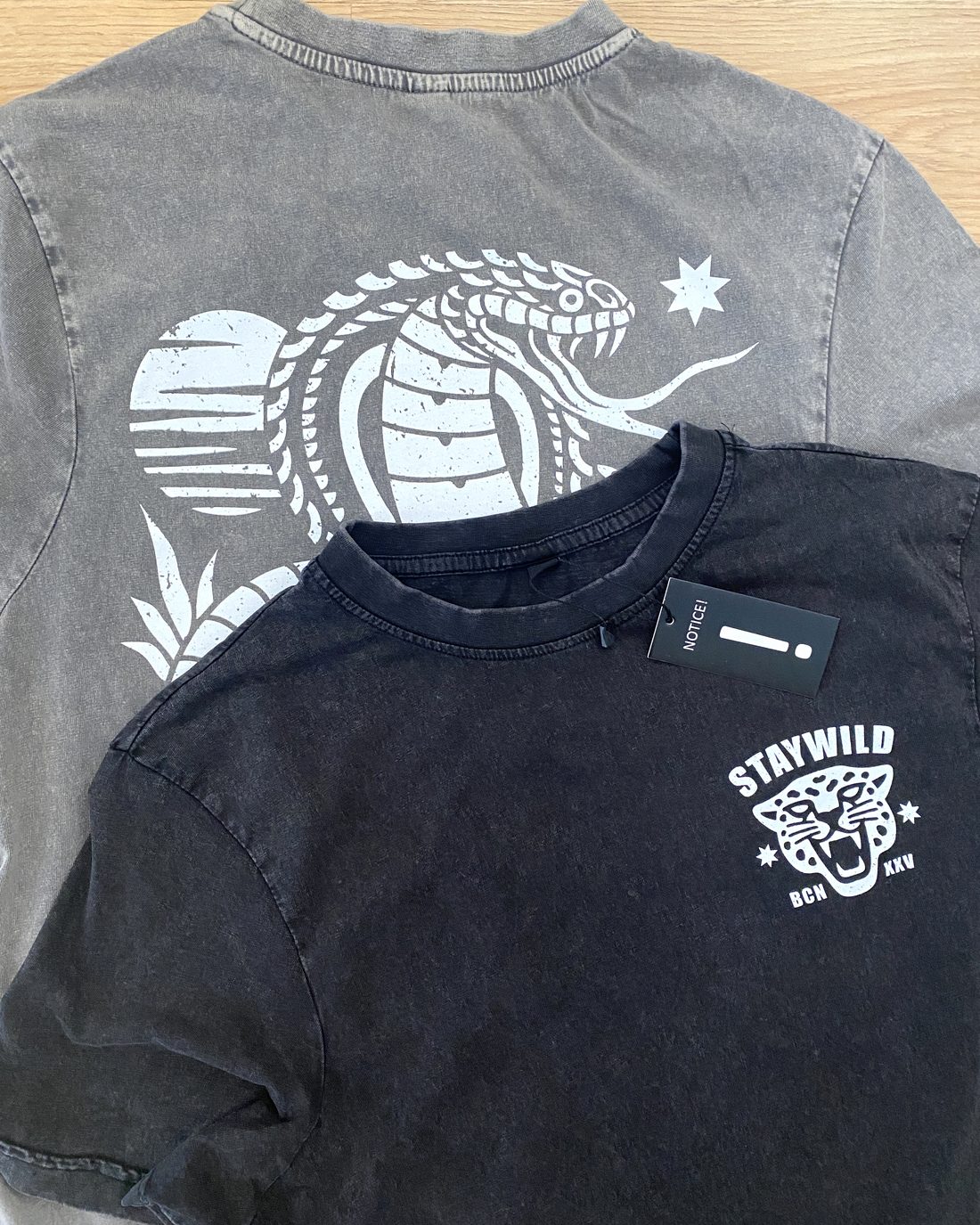 Dos camisetas de merch con estampado a una tinta sobre prenda lavada